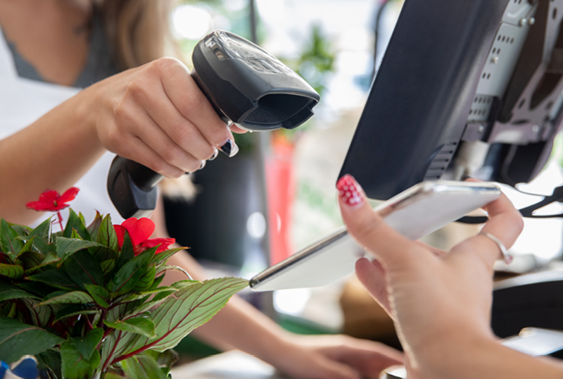 A barcode scanner scanning a loyalty app on a mobile phone